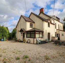 A house with gravel outdoor area and garden furniture at Craig Y Glyn Cottage Pwllheli