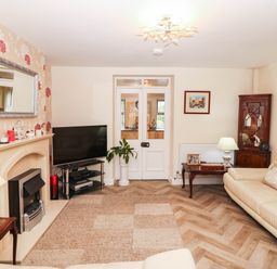 A living room with a television and sofa at Craig Y Glyn Cottage Pwllheli