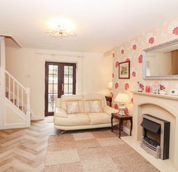 A living room with a sofa and fireplace at Craig Y Glyn Cottage in Pwllheli