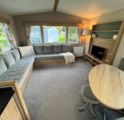 A living room with a sofa and a table at Hafan y Mor - 159 Snowdonia Pwllheli