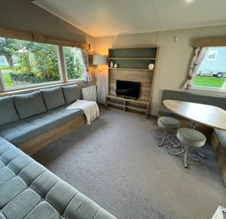 A living room with a sofa and table at Hafan y Mor - 159 Snowdonia Pwllheli