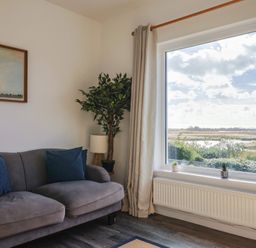 A living room with a sofa and a large window at Bay View in Weymouth