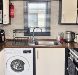 A kitchen with a washing machine and stove at 3 Bedroom Seafront Caravan, Sleeps 6 with Parking