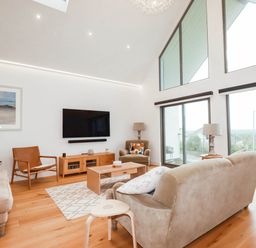 A living room with a sofa, coffee table, television and armchair at 1 Endellion View Wadebridge