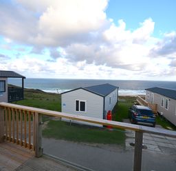 View of mobile homes and sea from a deck at Perran Sands Holiday Park - 615 Chy-an-Mor Perranporth
