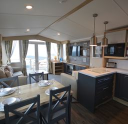 A kitchen with dining area and seating at Perran Sands Holiday Park - 620 Chy An Mor in Perranporth