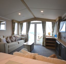 A living room with a sofa and television at Perran Sands Holiday Park - 620 Chy An Mor Perranporth