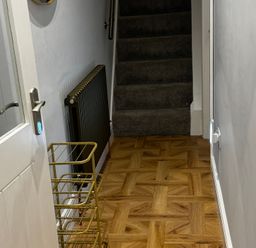 A hallway with a staircase and a radiator at Jacks Place in Whitby