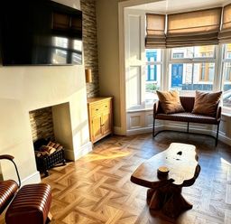A living room with a television and wooden furniture at Jacks Place in Whitby
