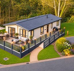A house with a deck and seating area at Hoburne Devon Bay - Woodland Glade 24 Paignton