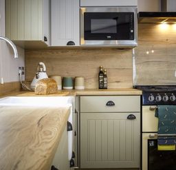 A kitchen with sink, stove, and countertop at Hoburne Devon Bay - Woodland Glade 24 in Paignton