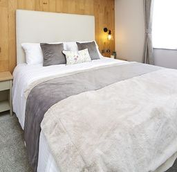 A bedroom with a bed and bedside table at Hoburne Devon Bay - Woodland Glade 24 in Paignton