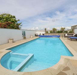 An outdoor swimming pool with a seating area and sun loungers surrounding it at Old Higher Lighthouse Stopes Cottage in Portland Bill