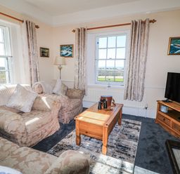 A living room with a coffee table and sofa at Old Higher Lighthouse Stopes Cottage Portland Bill