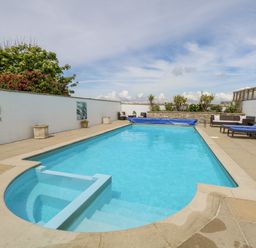 An outdoor swimming pool with lounge chairs and plants at Old Higher Lighthouse Branscombe Lodge Portland Bill