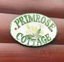 A nameplate for Primrose Cottage displayed on a wooden surface at Primrose Lodge in Saltburn-by-the-Sea