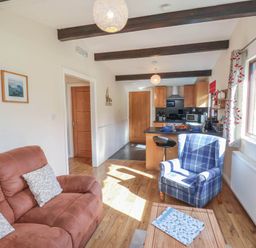 A living room with a sofa and an armchair at Primrose Lodge in Saltburn-by-the-Sea