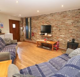 A living room with two sofas and a television at Cooper Cottage in Potto near Stokesley