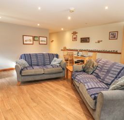 A living room with a sofa and dining area at Cooper Cottage in Potto near Stokesley