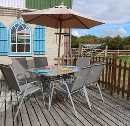 An outdoor seating area with a table and chairs at Cooper Cottage Potto near Stokesley
