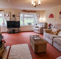 A living room with sofas and a television at The Lodge in Old Buckenham near Attleborough