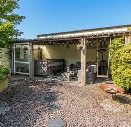 An outdoor garden with seating and a hot tub at Yr Hen Llaethdy in Blaen-Cil-Llech near Newcastle Emlyn