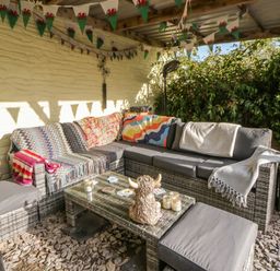An outdoor seating area with a sofa and table at Yr Hen Llaethdy in Blaen-Cil-Llech near Newcastle Emlyn