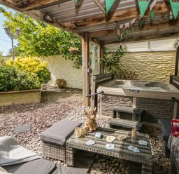 A garden area with a hot tub and outdoor seating at Yr Hen Llaethdy in Blaen-Cil-Llech near Newcastle Emlyn