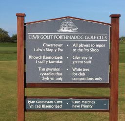 A golf course sign with rules and instructions in Welsh and English at Porthmadog Golf Club