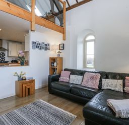 A living room with a sofa and coffee table at Eglwys St Cynfil Penrhos near Pwllheli