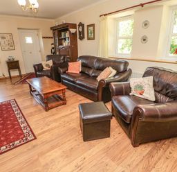 A living room with leather sofas a wooden coffee table and a television at Drovers Rest in Otterburn