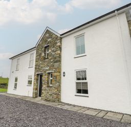A house with a stone wall and windows at Chapel House in Elim near Llanddeusant