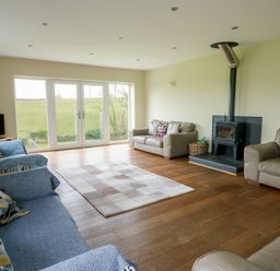 A living room with a wood burner and sofas at Chapel House in Elim near Llanddeusant