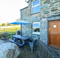 An outdoor seating area with a table and chairs at Tyddyn in Dyffryn Ardudwy