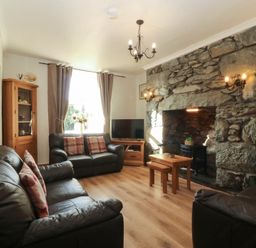 A living room with sofas and a fireplace at Tyddyn in Dyffryn Ardudwy