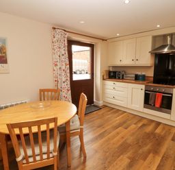 A kitchen with a dining table and appliances at The Old Bothy Bolton Low Houses near Wigton