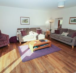 A living room with a sofa and armchairs at The Old Grainstore Bolton Low Houses near Wigton
