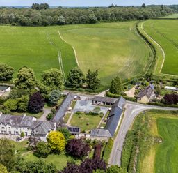 An aerial view of a countryside property with fields and trees at The Old Stables in Winterborne Stickland