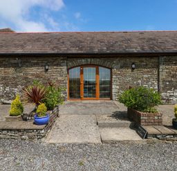 An entrance with double doors and potted plants at The Dairy in Penuel near Llanmorlais