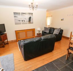 A living room with a television and seating area at The Dairy in Penuel near Llanmorlais