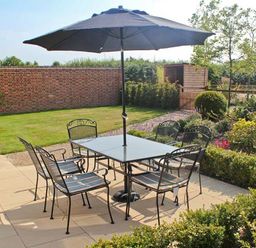 An outdoor patio with a table and six chairs under a large umbrella at Moat Farm Cottage in Wood Dalling