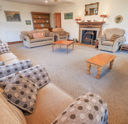 A living room with sofas and a fireplace at Ghyll Bank House Staveley near Windermere