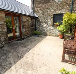 An outdoor area with a bench and planters at The Stall in Penuel near Llanmorlais