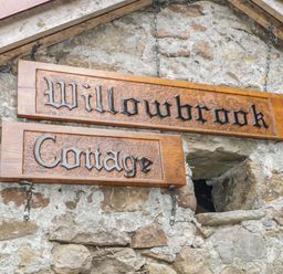 A wooden sign with the words Willowbrook Cottage mounted on a stone wall at Willowbrook Cottage in Askill County Leitrim