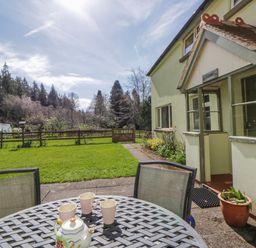 A garden with a table and teapot at Gardener's Cottage in Llanwrthwl near Rhayader