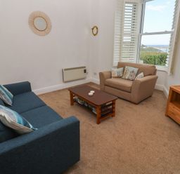 A living room with a sofa and armchair at Apartment 1 Llewellan in St Ives
