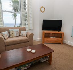 A living room with a sofa and television at Apartment 1 Llewellan in St Ives