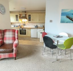 A living room with a kitchen area at Beach View in Benllech near Red Wharf Bay