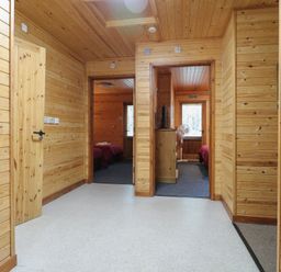 A wooden hallway with multiple doorways leading to bedrooms at Birch Lodge in Rosliston