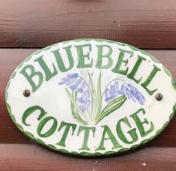 A decorative sign that reads Bluebell Cottage with flower design at Bluebell Lodge Saltburn-by-the-Sea